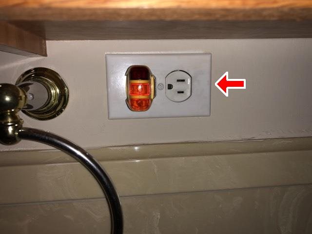 Outlet tester lit up showing an open ground, marked with a red arrow